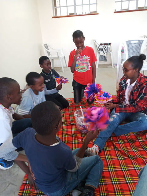 A CAN facilitator and children in a craft learning session